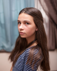 Girl with a serious look on her face during an in home family photo session